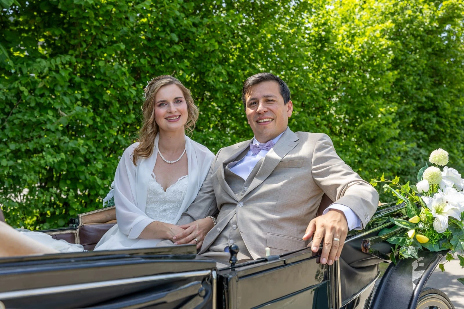 Brautpaar bei einer romantischen Hochzeitskutsche